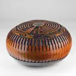 A round wooden bowl with an artistic design.